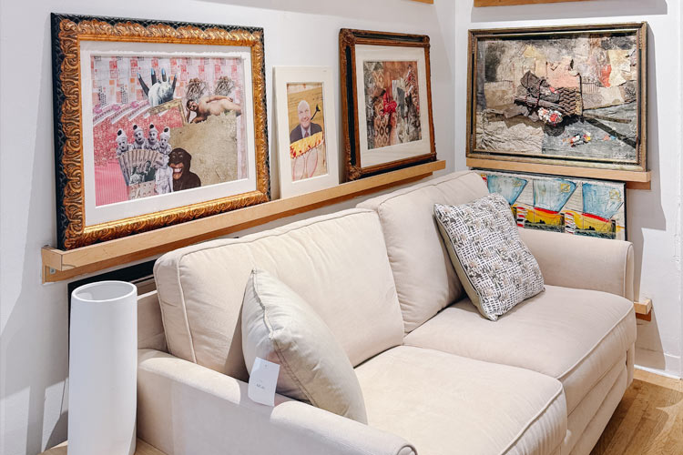 Cream-colored secondhand sofa displayed beneath framed artwork at Housing Works Thrift Shop Chelsea.