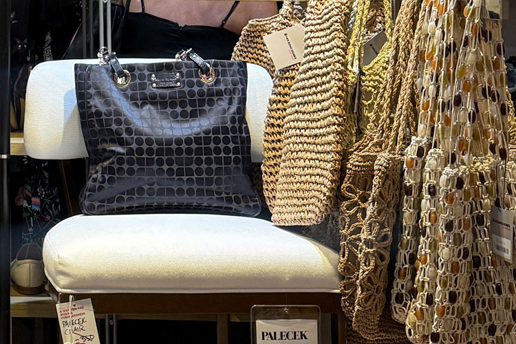 Secondhand designer handbag displayed beside woven and beaded bags.